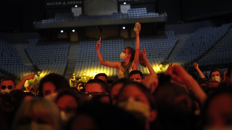 Thousands of people, masked and tested for the virus, pack inside a Paris concert hall as part of a public health experiment to prepare the country to host big events again, in Paris, Saturday, May 29, 2021. The concert in the AccorHotels Arena in eastern Paris features 1980s French rock band Indochine and DJ Etienne de Crecy. (AP Photo/Francois Mori)