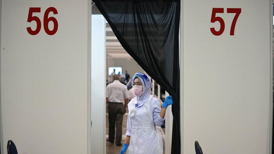 A man receives the Pfizer's vaccine for the coronavirus at a vaccination center in Kuala Lumpur, Malaysia, Monday, May 31, 2021. An exhibition center in Malaysia has been turned into the country's first mega vaccination center as the government aims to speed up inoculations amid a sharp spike in infections. (AP Photo/Vincent Thian)