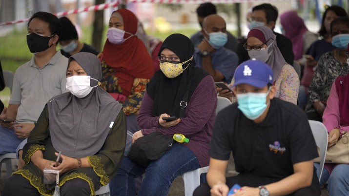 Virus Outbreak Malaysia Malaysians wait outside a community hall for coronavirus testing at a COVID-19 testing center in Shah Alam, outskirts of Kuala Lumpur, Malaysia, Thursday, May 27, 2021. Malaysia's latest coronavirus surge has been taking a turn for the worse as surging numbers and deaths have caused alarm among health officials, while cemeteries in the capital are dealing with an increasing number of deaths. (AP Photo/Vincent Thian)