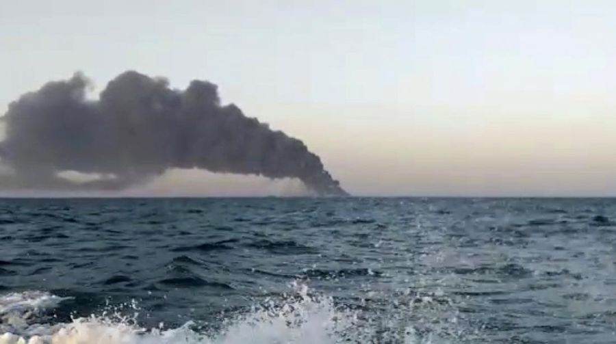 This photo made available by Asriran.com on Wednesday, June 2, 2021 shows personnel standing on Iran's navy support ship Kharg after being caught on fire in the Gulf of Oman. Kharg, the largest warship in the Iranian navy caught fire and later sank Wednesday in the Gulf of Oman under unclear circumstances, semiofficial news agencies reported. (Asriran.com via AP)