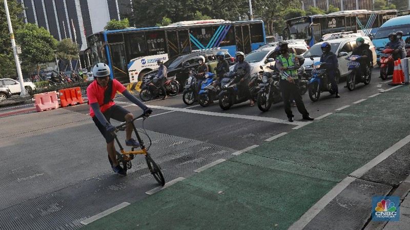 Petugas kepolisian menghalau setiap sepeda yang berada di luar jalur di kawasan Sudirman - Thamrin, Jakarta Pusat, Rabu (2/6/2021). (CNBC Indonesia/Andrean Kristianto)