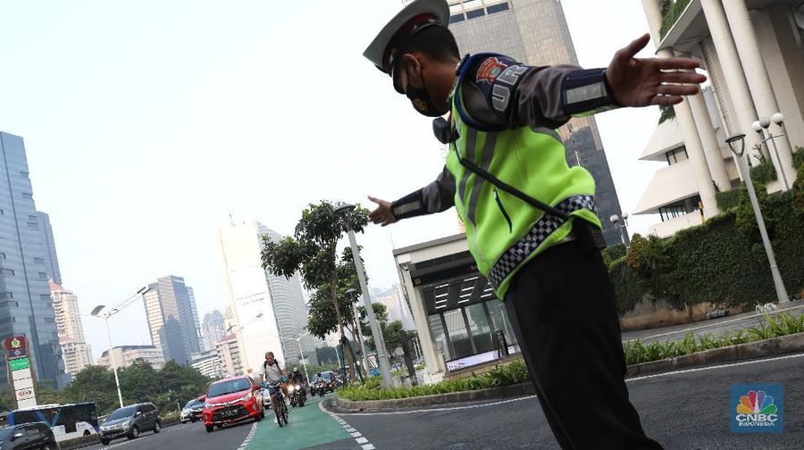 Petugas kepolisian menghalau setiap sepeda yang berada di luar jalur di kawasan Sudirman - Thamrin, Jakarta Pusat, Rabu (2/6/2021). (CNBC Indonesia/Andrean Kristianto)