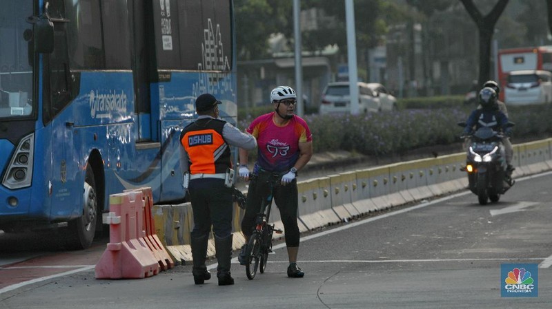 Petugas kepolisian menghalau setiap sepeda yang berada di luar jalur di kawasan Sudirman - Thamrin, Jakarta Pusat, Rabu (2/6/2021). (CNBC Indonesia/Andrean Kristianto)