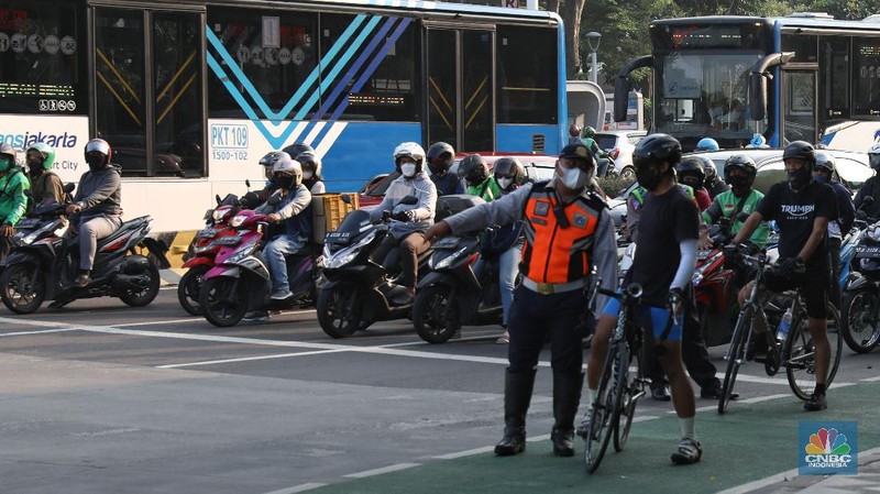 Petugas kepolisian menghalau setiap sepeda yang berada di luar jalur di kawasan Sudirman - Thamrin, Jakarta Pusat, Rabu (2/6/2021). (CNBC Indonesia/Andrean Kristianto)
