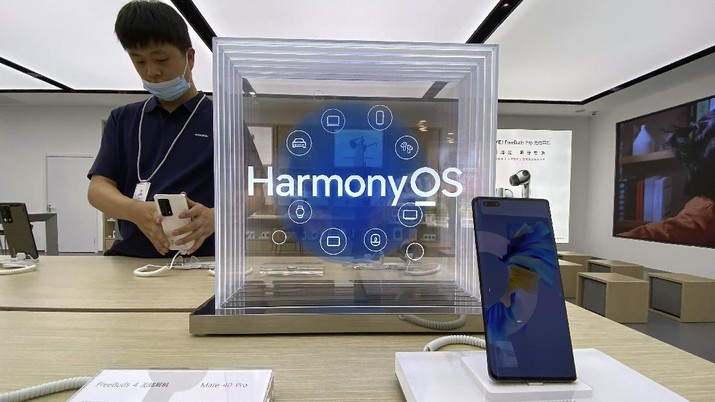 China Huawei OS A worker adjusts a phone near a display promoting the HarmonyOS at a Huawei store in Beijing on Thursday, June 3, 2021. Huawei launched its own HarmonyOS mobile operating system on its handsets on Wednesday as it adapts to having lost access to Google mobile services two years ago after the U.S. put the Chinese telecommunications company on a trade blacklist. (AP Photo/Ng Han Guan)