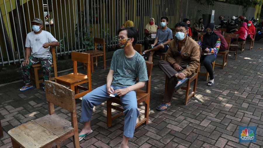 Tenaga kesehatan menyuntikan vaksin kepada warga di MTs As-Syafiiyah, Cilangkap, Jakarta, Kamis (3/6/2021). Vaksinasi massal di zona merah RT 03/ RW 03 Cilangkap akibat klaster halal bi halal itu dilakukan terhadap warga yang telah menjalani tes usap dengan hasil negatif. Vaksinasi diberikan kepada warga yang sebelumnya telah dinyatakan negatif Covid-19 hasil swab PCR. (CNBC Indonesia/Andrean Kristianto)