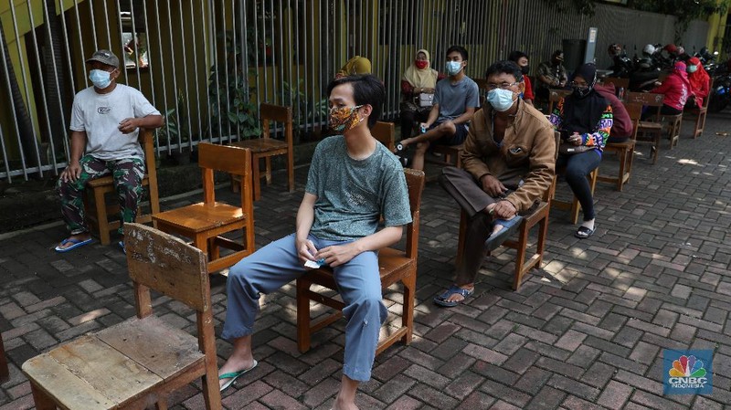 Tenaga kesehatan menyuntikan vaksin kepada warga di MTs As-Syafiiyah, Cilangkap, Jakarta, Kamis (3/6/2021). Vaksinasi massal di zona merah RT 03/ RW 03 Cilangkap akibat klaster halal bi halal itu dilakukan terhadap warga yang telah menjalani tes usap dengan hasil negatif. Vaksinasi diberikan kepada warga yang sebelumnya telah dinyatakan negatif Covid-19 hasil swab PCR. (CNBC Indonesia/Andrean Kristianto)