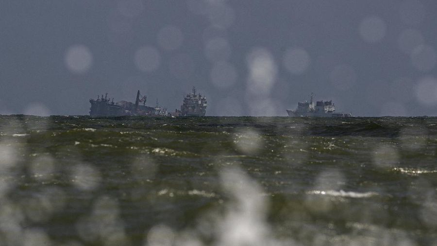 The MV X-Press Pearl, left, is seen pulled by other navel vessels at Kapungoda, where it is anchored off Colombo port on the outskirts of Colombo, Sri Lanka, Wednesday, June 2, 2021. Salvage experts were attempting to tow the fire-stricken container ship that had been loaded with chemicals into the deep sea as the vessel started to sink Wednesday off Sri Lanka's main port, officials said. Water submerged the MV X-Press Pearl's quarterdeck a day after firefighters extinguished a blaze that had been burning for 12 days. (AP Photo/Eranga Jayawardena)