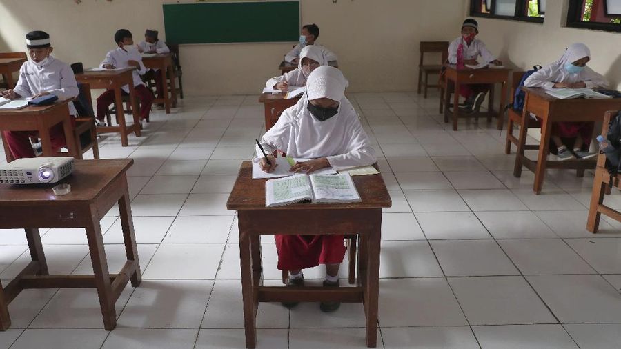 A student wearing a face mask sits spaced apart during a trial run of a class with COVID-19 protocols at an elementary school in Jakarta, Indonesia, Friday, June 4, 2021. The world's fourth-most populous country, with about 275 million people, has reported more coronavirus cases than any other Southeast Asian country. (AP Photo/Tatan Syuflana)