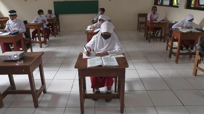 A student wearing a face mask sits spaced apart during a trial run of a class with COVID-19 protocols at an elementary school in Jakarta, Indonesia, Friday, June 4, 2021. The world's fourth-most populous country, with about 275 million people, has reported more coronavirus cases than any other Southeast Asian country. (AP Photo/Tatan Syuflana)