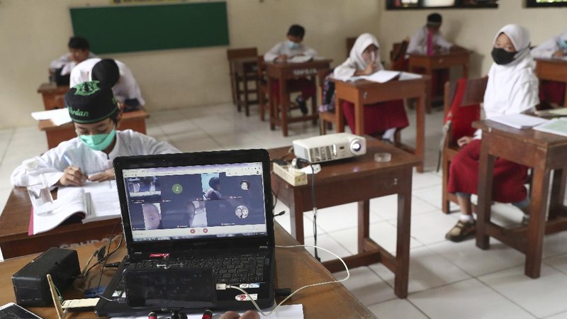 A student wearing a face mask sits spaced apart during a trial run of a class with COVID-19 protocols at an elementary school in Jakarta, Indonesia, Friday, June 4, 2021. The world's fourth-most populous country, with about 275 million people, has reported more coronavirus cases than any other Southeast Asian country. (AP Photo/Tatan Syuflana)