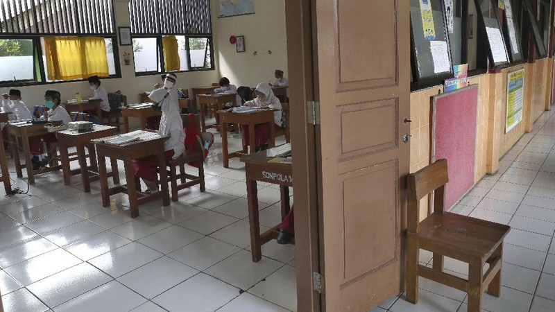 A student wearing a face mask sits spaced apart during a trial run of a class with COVID-19 protocols at an elementary school in Jakarta, Indonesia, Friday, June 4, 2021. The world's fourth-most populous country, with about 275 million people, has reported more coronavirus cases than any other Southeast Asian country. (AP Photo/Tatan Syuflana)