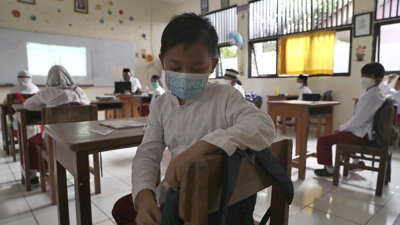 A student wearing a face mask sits spaced apart during a trial run of a class with COVID-19 protocols at an elementary school in Jakarta, Indonesia, Friday, June 4, 2021. The world's fourth-most populous country, with about 275 million people, has reported more coronavirus cases than any other Southeast Asian country. (AP Photo/Tatan Syuflana)