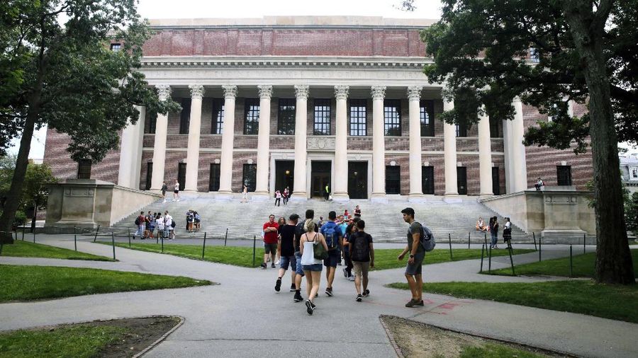 FILE - In this Aug. 13, 2019 file photo, students walk near the Widener Library in Harvard Yard at Harvard University in Cambridge, Mass. Ismail Ajjawi, 17, a Palestinian student who was denied entry to the United States just days before he was scheduled to start classes at Harvard University, has been admitted to the country. The university confirmed that Ajjawi was on campus as classes began Tuesday, Sept. 3, 2019. (AP Photo/Charles Krupa, File)