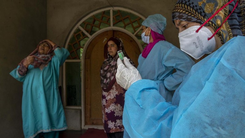Petugas medis mendatangi rumah warga yang akan di Vaksin di India. (AP/Dar Yasin)