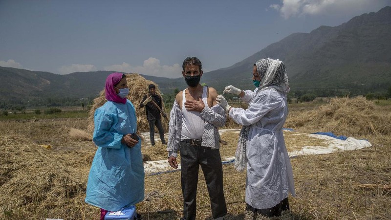 Petugas medis mendatangi rumah warga yang akan di Vaksin di India. (AP/Dar Yasin)