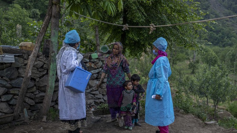 Petugas medis mendatangi rumah warga yang akan di Vaksin di India. (AP/Dar Yasin)