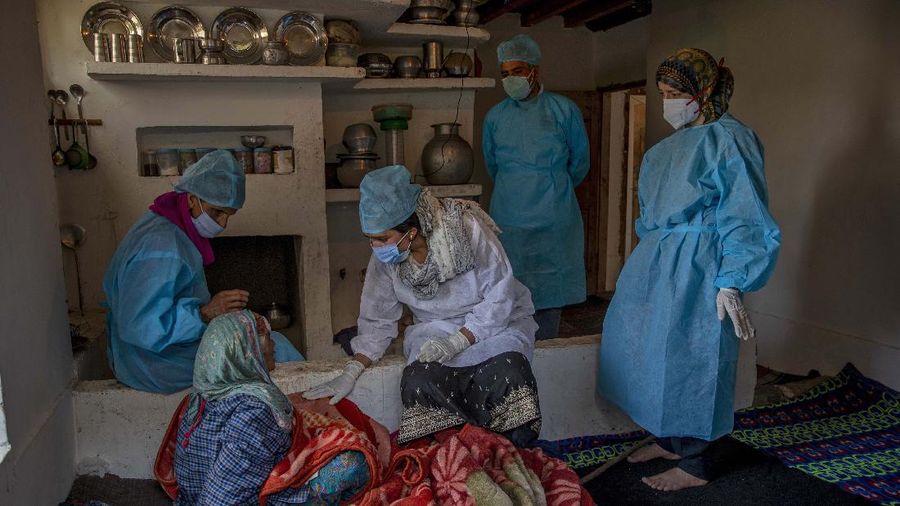 Petugas medis mendatangi rumah warga yang akan di Vaksin di India. (AP/Dar Yasin)