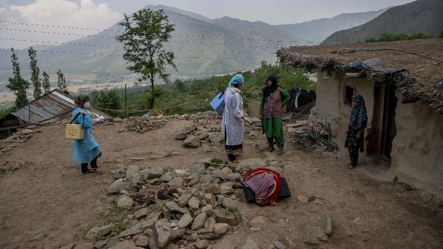 Petugas medis mendatangi rumah warga yang akan di Vaksin di India. (AP/Dar Yasin)
