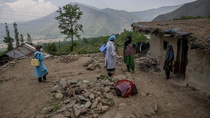 Petugas medis mendatangi rumah warga yang akan di Vaksin di India. (AP/Dar Yasin)