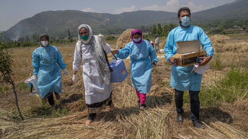 Petugas medis mendatangi rumah warga yang akan di Vaksin di India. (AP/Dar Yasin)