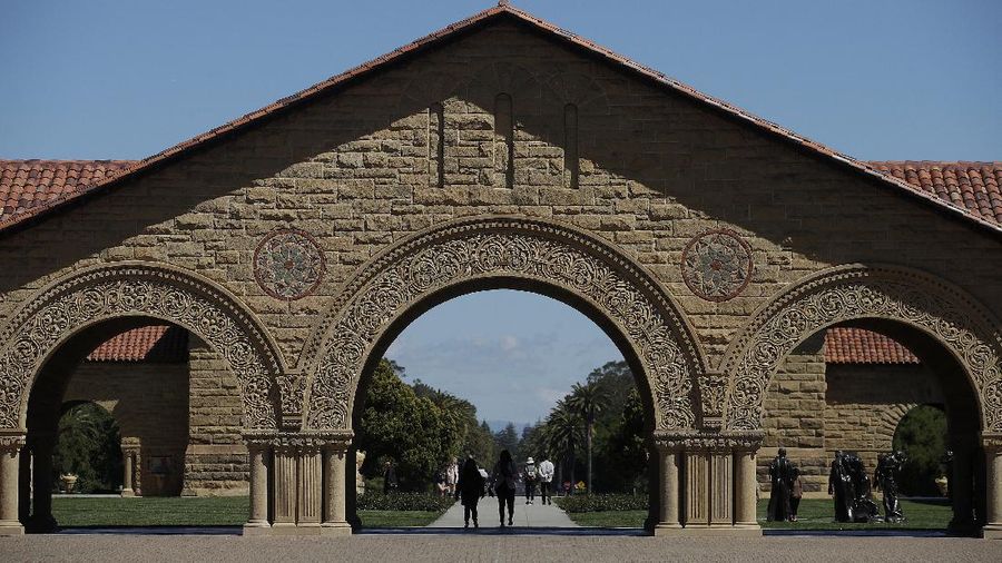 FILE - In this April 9, 2019 file photo, pedestrians walk on the campus at Stanford University in Stanford, Calif. Authorities are investigating the on-campus death of a Stanford University undergraduate student but do not suspect foul play. Deputies responded Friday, Jan. 17, 2020 to a medical emergency at a residence. The Stanford Daily reported that it was the Theta Delta Chi fraternity house. The man, who was not identified, died at the scene. (AP Photo/Jeff Chiu, File)