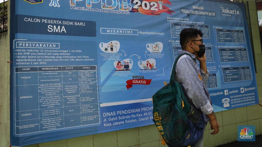 Orang tua murid mencari informasi pengajuan akun untuk mengikuti proses penerimaan Peserta Didik Baru (PPDB) Tahun Pelajaran 2021/2022 di Sekolah SMA Negeri 87 Jakarta, Senin (7/6). Proses penerimaan Peserta Didik Baru (PPDB) Tahun Pelajaran 2021/2022 di DKI Jakarta yang mulai dibuka sejak hari ini, Senin (7/6). Pada tahun ini, ada empat jalur pendaftaran yang dibuka meliputi jalur prestasi, afirmasi, zonasi, perpindahan tugas orang tua dan anak guru. Pada hari ini 7 Juni hingga 9 Juni 2021 PPDB dibuka khusus untuk jalur prestasi. Persyaratan PPDB Jakarta 2021 adalah ketentuan yang mewajibkan bahwa sekolah-sekolah negeri atau milik pemerintah yang ada di wilayah DKI Jakarta, hanya boleh menerima siswa yang terdaftar di Kartu Keluarga (KK) yang diterbitkan oleh Dinas Catatan Sipil dan Kependudukan Provinsi DKI Jakarta. Aturan ini PPDB DKI Jakarta 2021 juga telah diundangkan pada tanggal yang sama, dan dicatatkan dalam Berita Daerah Provinsi DKI Jakarta Tahun 2021 nomor 55005.
Pada pasal 1 ayat (11) Pergub No 32 Tahun 2021 tersebut meyebutkan, 
