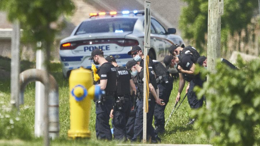 London Police investigate the scene of a car crash in London, Ontario on Monday, June 7, 2021. Police say multiple people have died after several pedestrians were struck by a car Sunday night. (Geoff Robins/The Canadian Press via AP)