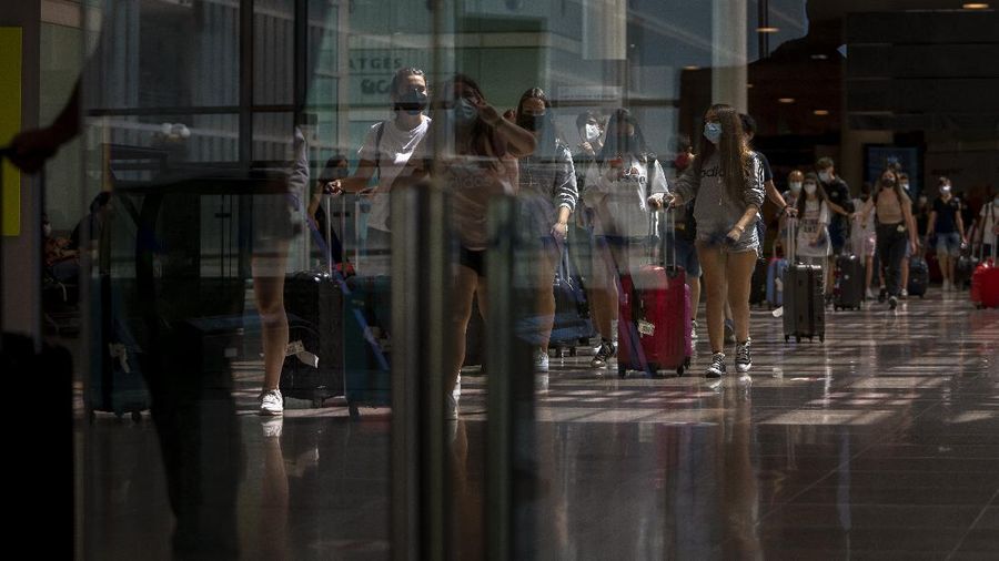 Sejumlah penumpang pesawat terbang tiba di bandara Barcelona, Spanyol. (AP/Emilio Morenatti)