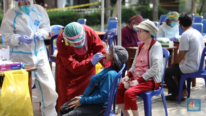 Swab Antigen di Pemukiman Lockdown Micro Warga menjalani test antigen untuk mendeteksi Covid-19 di Kelurahan Kayu Putih, Jakarta, Selasa (8/6). Satu RT di Kelurahan Kayu Putih, Jakarta Timur, yakni RT 11, menerapkan lockdown atau penguncian wilayah sementara usai 22 warga dinyatakan positif covid-19.kasus aktif Covid-19 di wilayah RT 11/09 tersebut berasal dari klaster keluarga, namun ada kemungkinan besar juga berasal dari klaster kerumunan mengingat di wilayah tersebut terdapat taman yang digunakan oleh para warga secara bebas dalam beraktivitas. Dalam menangani kasus aktif Covid-19 di wilayah tersebut, pihaknya tak hanya menerapkan mikro-lockdown. Namun juga turut mendistribusikan bantuan-bantuan terhadap warga yang terdampak agar dapat melewati masa pandemi Covid-19. Puluhan warga yang positif itu kini menjalani isolasi di berbagai tempat. Bagi yang bergejala, dibawa ke rumah sakit, sisanya menjalani isolasi di Wisma Atlet dan rumah masing-masing.a (CNBC Indonesia/ Muhammad Sabki)