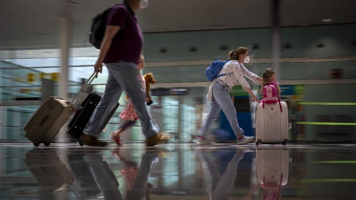 Tourists arrive at Barcelona airport, Spain, Monday, June 7, 2021. Spain is trying to ramp up its tourism industry by welcoming from Monday vaccinated visitors from most countries, as well as all Europeans who prove that they are not infected with the coronavirus. (AP Photo/Emilio Morenatti)