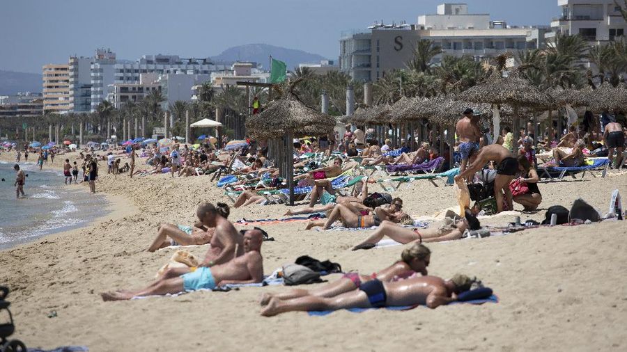 Tourists sunbathe on the beach at the Spanish Balearic Island of Mallorca, Spain, Monday, June 7, 2021. Spain is jumpstarting its summer tourism season by welcoming vaccinated visitors from most countries as well as European visitors who can prove they are not infected with coronavirus. It also reopened its ports to cruise ship stops on Monday. (AP Photo/Francisco Ubilla)