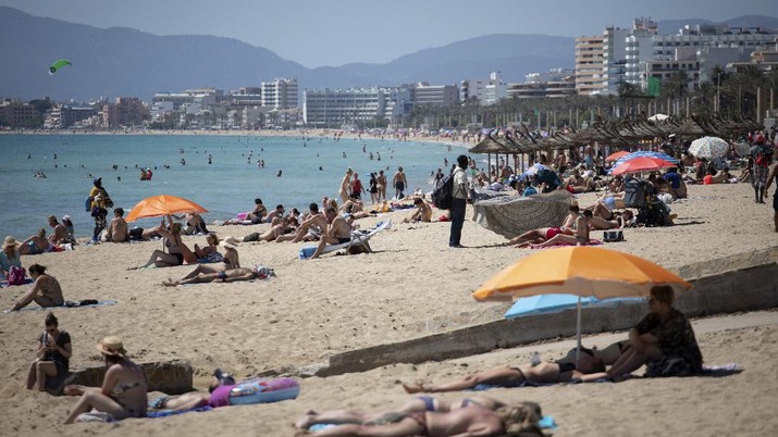 Tourists enjoy the beach at the Spanish Balearic Island of Mallorca, Spain, Monday, June 7, 2021. Spain is jumpstarting its summer tourism season by welcoming vaccinated visitors from most countries as well as European visitors who can prove they are not infected with coronavirus. It also reopened its ports to cruise ship stops on Monday. (AP Photo/Francisco Ubilla)