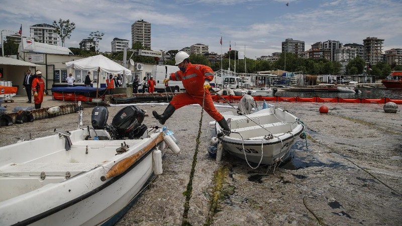 People ride a canoe by the Caddebostan shore, on the Asian side of Istanbul, Tuesday, June 8, 2021, surrounded by a huge mass of marine mucilage, a thick, slimy substance made up of compounds released by marine organisms, in Turkey's Marmara Sea. Turkey’s president has promised to rescue the Marmara Sea from an outbreak of “sea snot” that is alarming marine biologists and environmentalists. A huge mass of marine mucilage has bloomed in Turkey’s Marmara and the adjoining Black and Aegean Seas. Turkish President Recep Tayyip Erdogan said untreated waste dumped into the Marmara Sea and climate change had caused the bloom of the thick, slimy substance made up of compounds released by marine organisms, Istanbul, Turkey’s largest city, borders the sea. (AP Photo/Kemal Aslan)