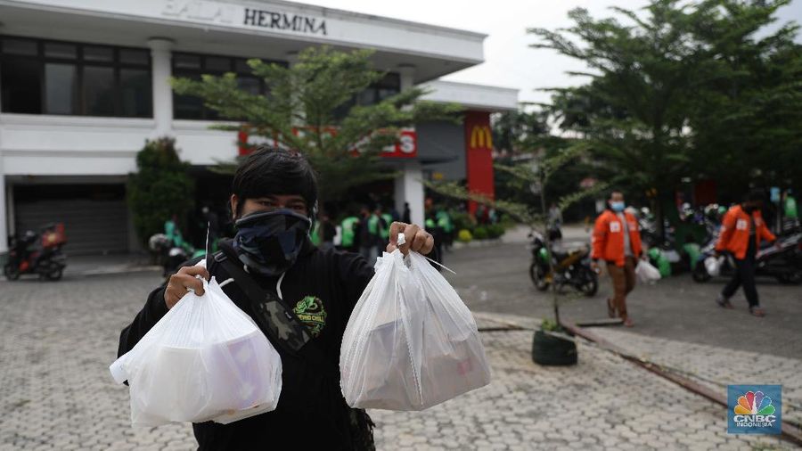 Puluhan ojol berkerumun untuk membeli promo BTS Meal di gerai McDonald's Mampang, Rabu (9/6/2021). Menu Mcdonald's yang berkolaborasi dengan BTS Meal dijual hari ini pukul 11.00 WIB. Pantauan CNBC Indonesia di MC Donald Mampang sejumlah petugas Satpol PP Satgas Covid-19 di lokasi mencoba berbicara kepada manager MC Donald. Karena ramainya ojol Drive thru di mampang ditiadakan Ternyata di sejumlah Mcdonald's terlihat antrian para driver ojek online yang mendapatkan pesanan masyarakat untuk BTS Meal tersebut. Nama BTS Meal dan BTSxMcD menduduki peringkat satu dan kedua Trending Topik Twitter Indonesia. Masing-masing telah dipenuhi sebanyak 52.900 tweet dan 12.200 tweet. Selain itu ada juga yang mengabarkan jika aplikasi ojek online ditutup. Serta outlet McDonald's dikabarkan penuh untuk memesan BTS Meal. Salah satu driver ojol mengatakan pada CNBC Indonesia bahwa ia sudah menunggu sejak pukul 11 hingga pukul 1.30 makanan belum juga bisa diambil. (CNBC Indonesia/ Muhammad Sabki)