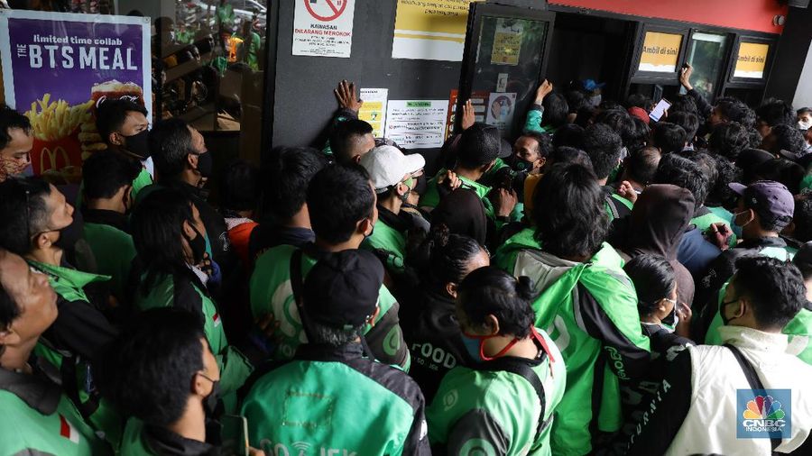Puluhan ojol berkerumun untuk membeli promo BTS Meal di gerai McDonald's Mampang, Rabu (9/6/2021). Menu Mcdonald's yang berkolaborasi dengan BTS Meal dijual hari ini pukul 11.00 WIB. Pantauan CNBC Indonesia di MC Donald Mampang sejumlah petugas Satpol PP Satgas Covid-19 di lokasi mencoba berbicara kepada manager MC Donald. Karena ramainya ojol Drive thru di mampang ditiadakan Ternyata di sejumlah Mcdonald's terlihat antrian para driver ojek online yang mendapatkan pesanan masyarakat untuk BTS Meal tersebut. Nama BTS Meal dan BTSxMcD menduduki peringkat satu dan kedua Trending Topik Twitter Indonesia. Masing-masing telah dipenuhi sebanyak 52.900 tweet dan 12.200 tweet. Selain itu ada juga yang mengabarkan jika aplikasi ojek online ditutup. Serta outlet McDonald's dikabarkan penuh untuk memesan BTS Meal. Salah satu driver ojol mengatakan pada CNBC Indonesia bahwa ia sudah menunggu sejak pukul 11 hingga pukul 1.30 makanan belum juga bisa diambil. (CNBC Indonesia/ Muhammad Sabki)