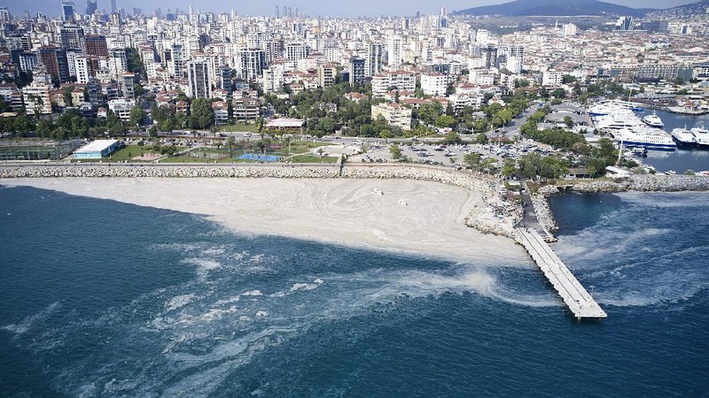 People ride a canoe by the Caddebostan shore, on the Asian side of Istanbul, Tuesday, June 8, 2021, surrounded by a huge mass of marine mucilage, a thick, slimy substance made up of compounds released by marine organisms, in Turkey's Marmara Sea. Turkey’s president has promised to rescue the Marmara Sea from an outbreak of “sea snot” that is alarming marine biologists and environmentalists. A huge mass of marine mucilage has bloomed in Turkey’s Marmara and the adjoining Black and Aegean Seas. Turkish President Recep Tayyip Erdogan said untreated waste dumped into the Marmara Sea and climate change had caused the bloom of the thick, slimy substance made up of compounds released by marine organisms, Istanbul, Turkey’s largest city, borders the sea. (AP Photo/Kemal Aslan)