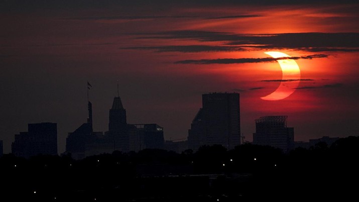 A partial solar eclipse rises over the Baltimore skyline, Thursday, June 10, 2021, seen from Arbutus, Md. (AP Photo/Julio Cortez)