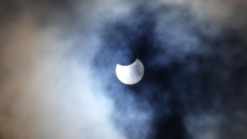 A man wears special glasses to watch the partial solar eclipse in Trafalgar Square in London, Thursday, June 10, 2021. (AP Photo/Frank Augstein)