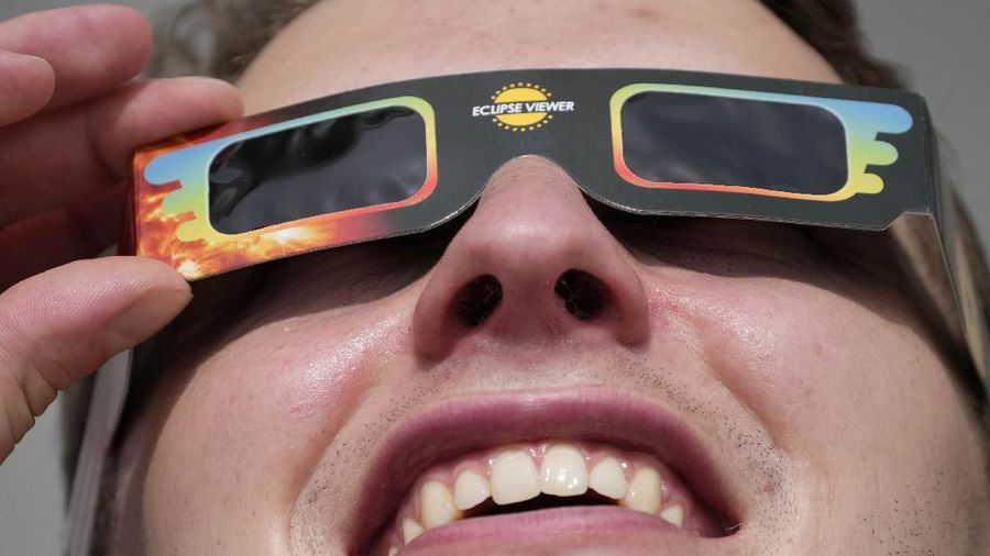 A man wears special glasses to watch the partial solar eclipse in Trafalgar Square in London, Thursday, June 10, 2021. (AP Photo/Frank Augstein)