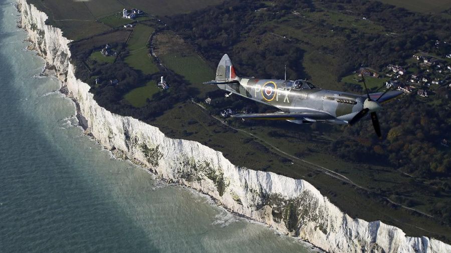 A World War II Spitfire, flies over the White Cliffs of Dover in Kent, England in a tribute to the fallen on Remembrance Day, Sunday Nov. 10, 2019. (Gareth Fuller/PA via AP)
