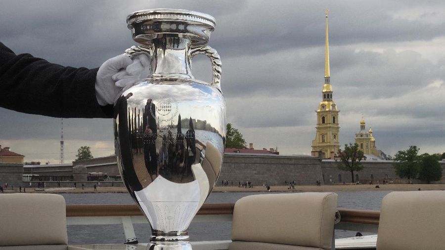 A security guard holds the EURO 2020 trophy on a boat floating down the Neva River during the official EURO 2020 trophy's tour in St.Petersburg, Russia, Saturday, May 22, 2021. St. Petersburg will host seven postponed UEFA EURO 2020 matches, including a quarter final. (AP Photo/Dmitri lovetsky)