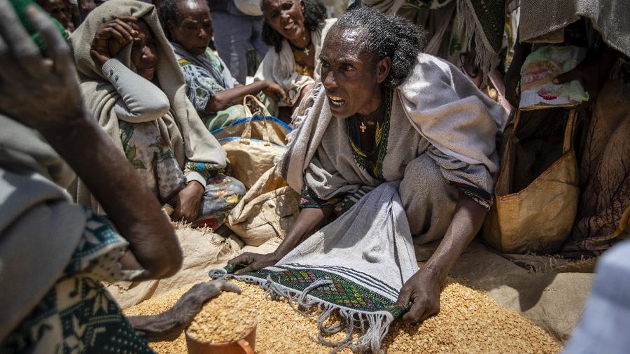 An Ethiopian woman argues with others over the allocation of yellow split peas after it was distributed by the Relief Society of Tigray in the town of Agula, in the Tigray region of northern Ethiopia, on Saturday, May 8, 2021. In war-torn Tigray, more than 350,000 people already face famine, according to the U.N. and other humanitarian groups. It is not just that people are starving; it is that many are being starved, The Associated Press found. (AP Photo/Ben Curtis)