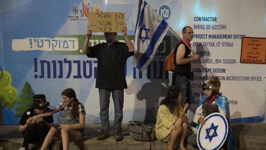 Israeli protesters hold signs during a demonstration against Israeli Prime Minister Benjamin Netanyahu outside his official residence in Jerusalem, Saturday, June 12, 2021. If all goes according to plan, Israel will swear in a new government on Sunday, ending Prime Minister Benjamin Netanyahu's record 12-year rule and a political crisis that inflicted four elections on the country in less than two years. (AP Photo/Ariel Schalit)