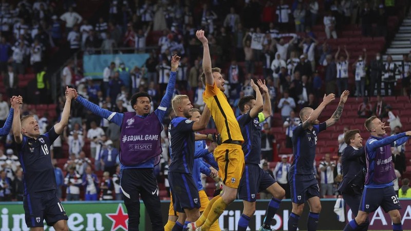 Finland's goalkeeper Lukas Hradecky punches the ball away from Denmark's Andreas Cornelius, center right, during the Euro 2020 soccer championship group B match between Denmark and Finland at Parken Stadium in Copenhagen, Saturday, June 12, 2021. (Stuart Franklin/Pool via AP)