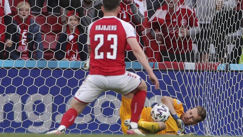 Finland's goalkeeper Lukas Hradecky punches the ball away from Denmark's Andreas Cornelius, center right, during the Euro 2020 soccer championship group B match between Denmark and Finland at Parken Stadium in Copenhagen, Saturday, June 12, 2021. (Stuart Franklin/Pool via AP)