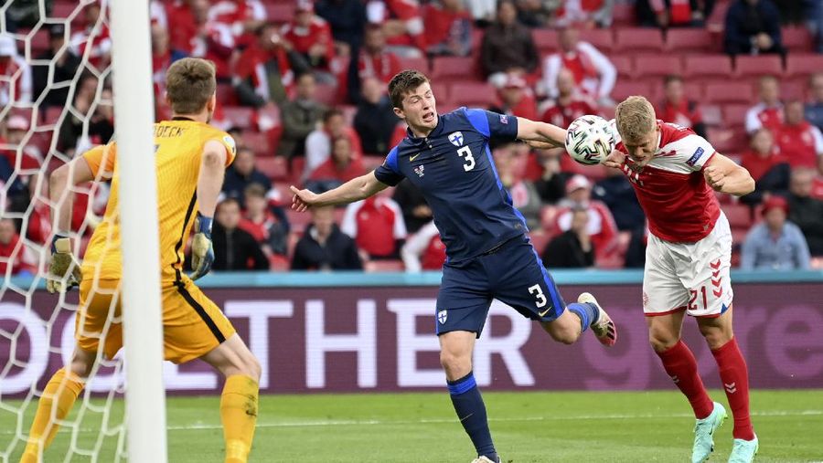 Finland's goalkeeper Lukas Hradecky punches the ball away from Denmark's Andreas Cornelius, center right, during the Euro 2020 soccer championship group B match between Denmark and Finland at Parken Stadium in Copenhagen, Saturday, June 12, 2021. (Stuart Franklin/Pool via AP)