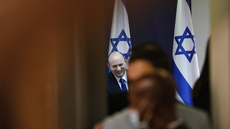 Israeli protesters march with a signs that reads 