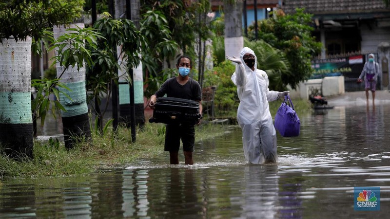 Nakes menjemput pasien covid-19 di tengah banjir. (CNBC Indonesia/ Muhammad Sabki)