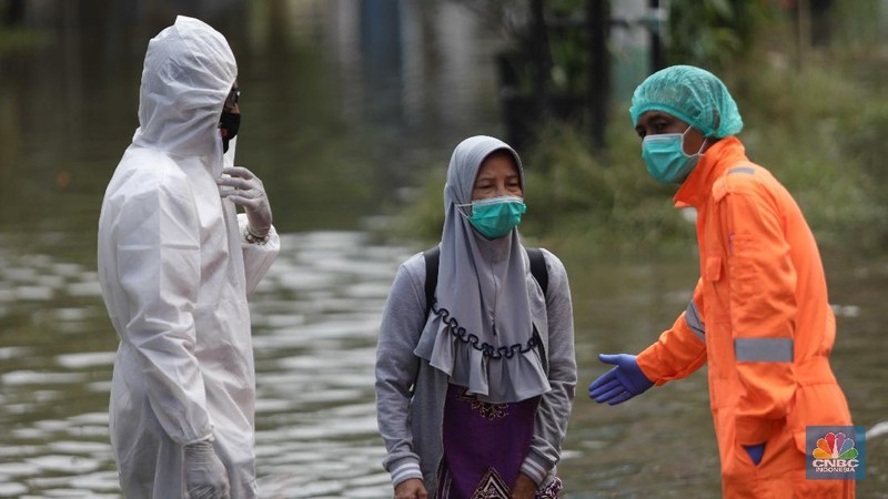 Nakes menjemput pasien covid-19 di tengah banjir. (CNBC Indonesia/ Muhammad Sabki)